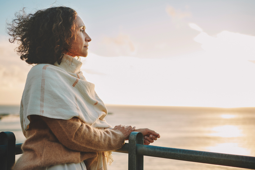 Stock photo of pensive woman looking out over water