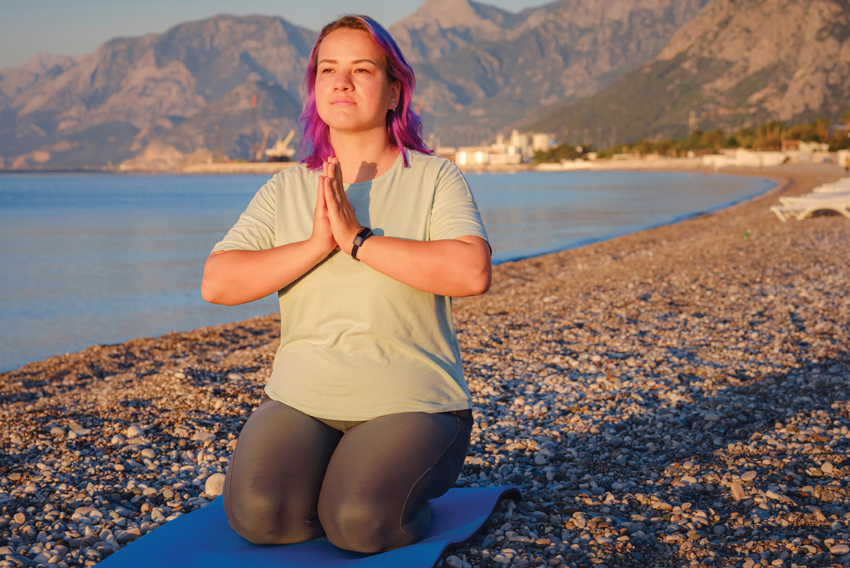 photo of a woman doing yoga on a beach