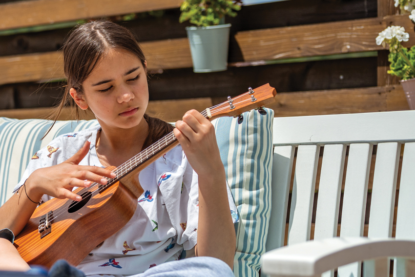 stock photo of a young person playing a ukulele