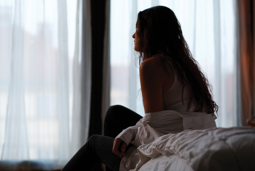 Stock photo of woman looking out a window
