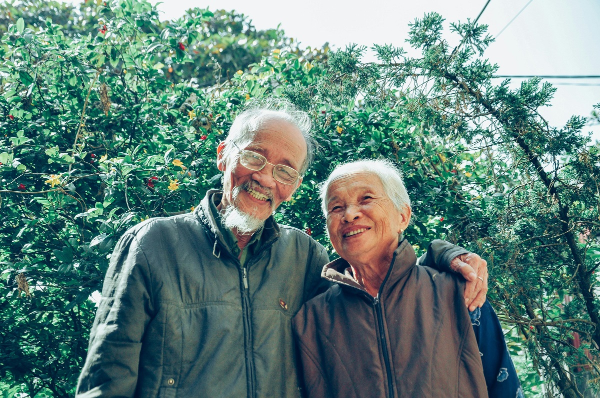 image of two older adults standing in a treed neighbourhood