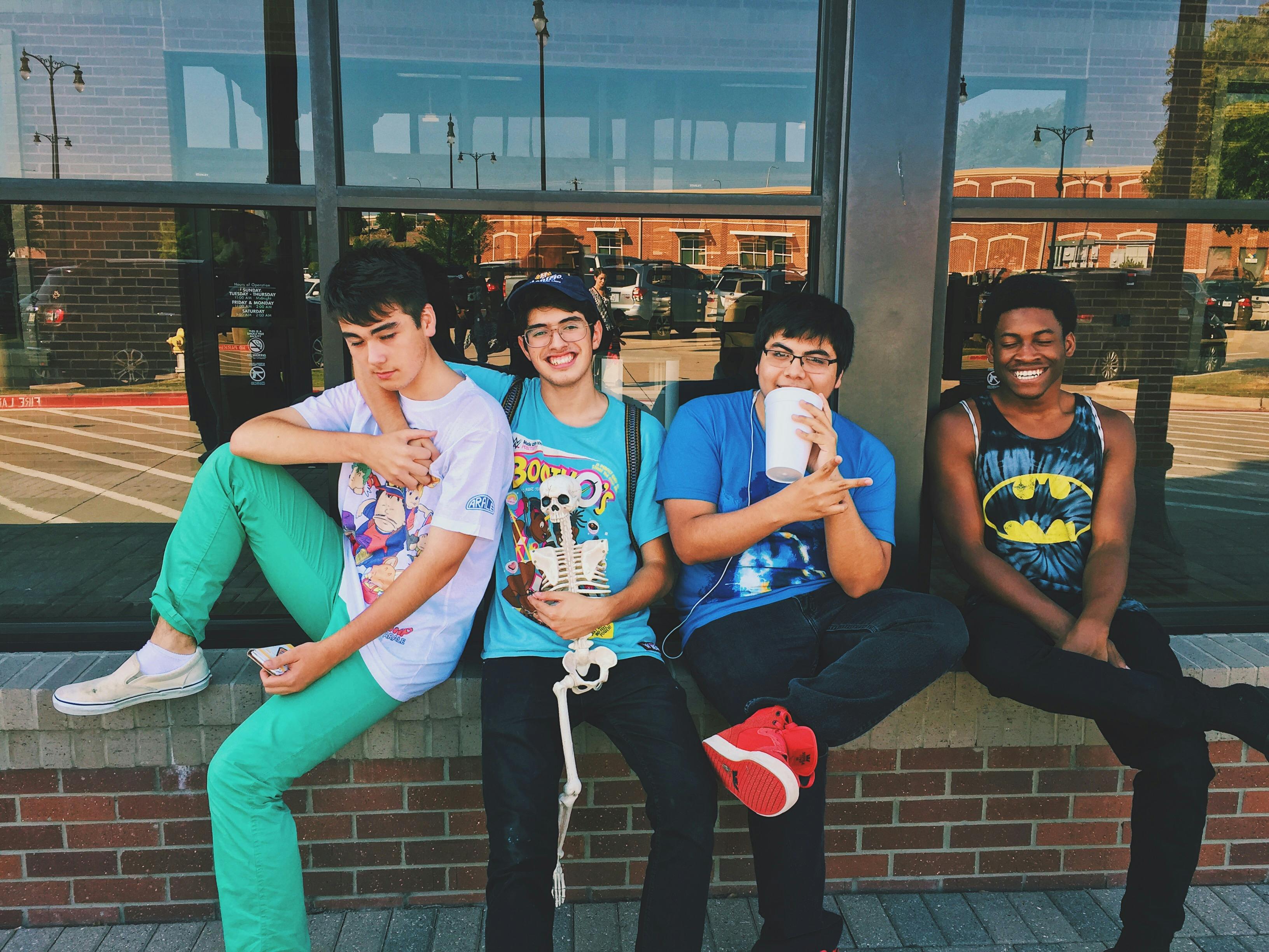 stock photo of four young men sitting outside and talking