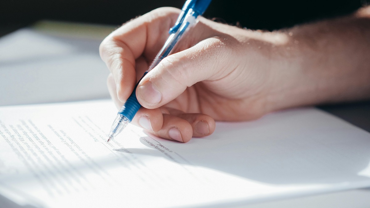 stock photo of a person filling in a form with a pen